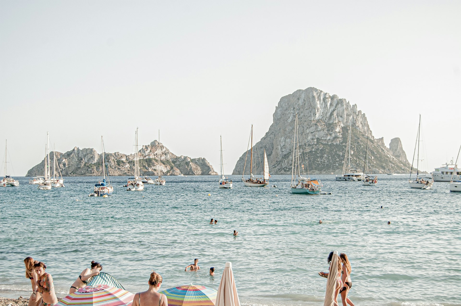 Swimmers and sailing boats facing Es Vedrà