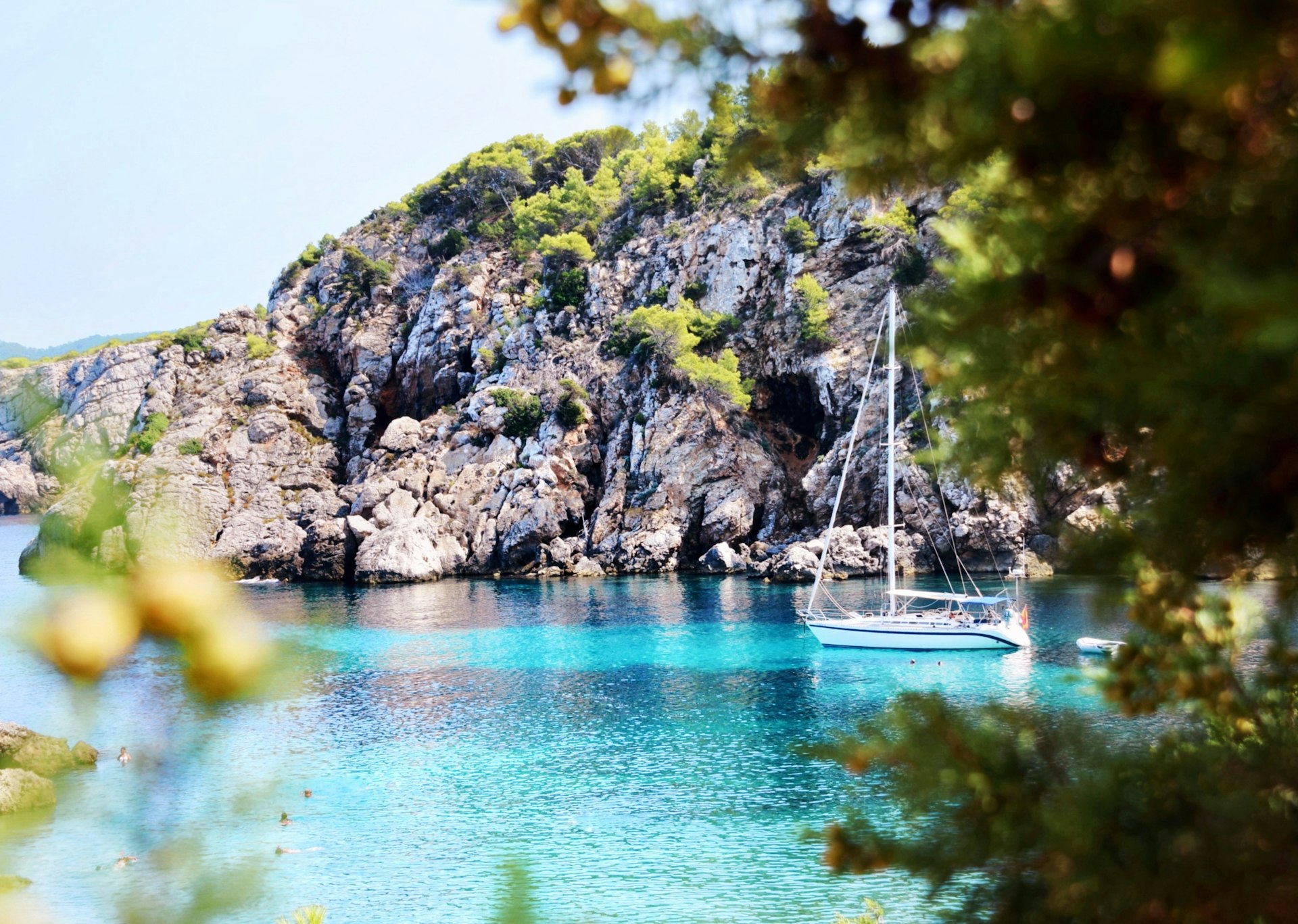 Sailing boat in a turquoise Ibiza cove